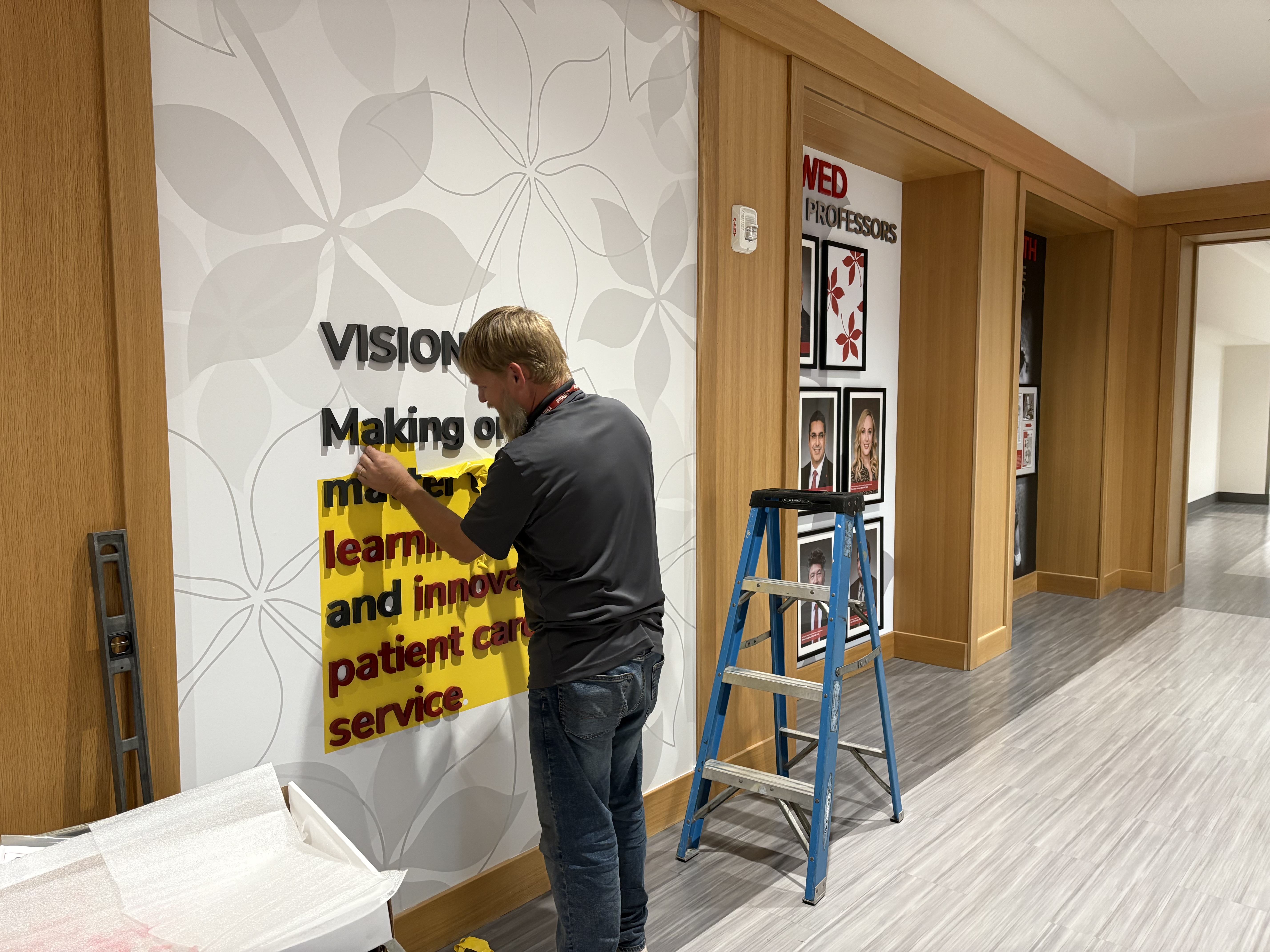 person installing 3-D lettering