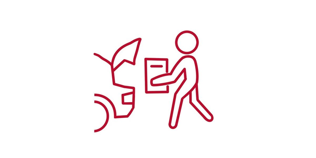 A person loading a box into the trunk of a car